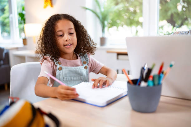 istock Multiracial girl doing her homework, at home for the dining table 2162101373