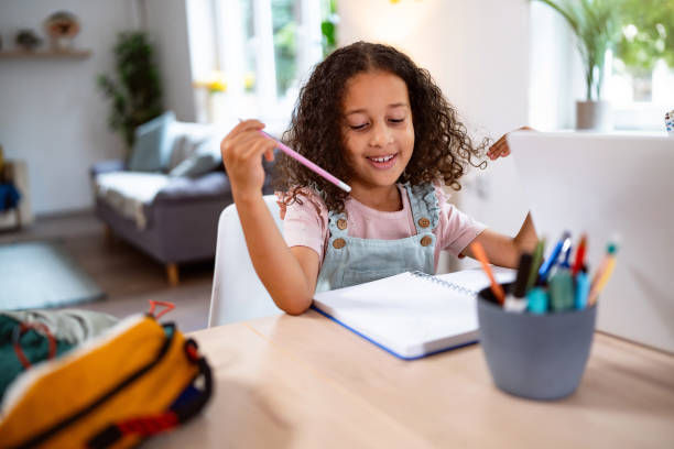 istock Multiracial girl doing her homework, at home for the dining table 2162101447