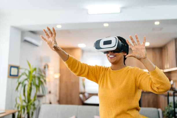 istock Young Woman Playing A Game On A Virtual Reality Headset At Home 2162101952