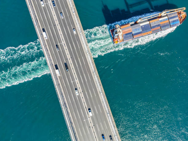 istock Aerial view of a cargo ship passing under bridge. Cargo Ship Beneath Bridge. 2162101981