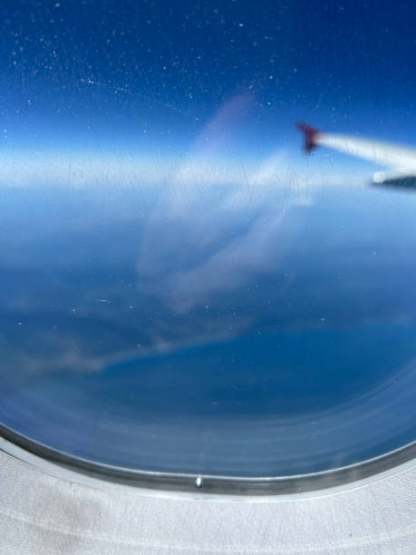 istock Blurred View from the airplane window. Beautiful cloudscape with blue sky. Wonderful panorama above white clouds as seen through window of an plane. Traveling by air concept. Selective focus. 2162102323