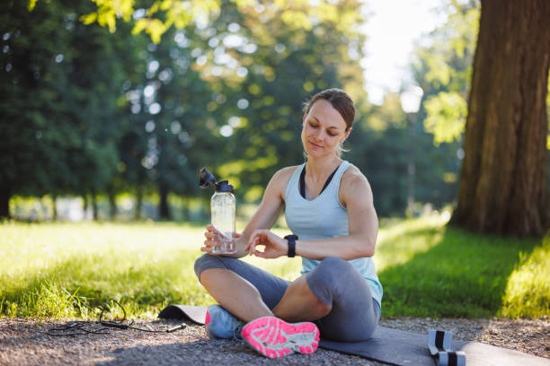 istock Caucasian Female Athlete in Park Checking Smartwatch 2162102792