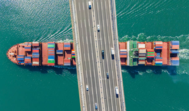 istock Aerial view of a cargo ship passing under bridge. Cargo Ship Beneath Bridge. 2162103004