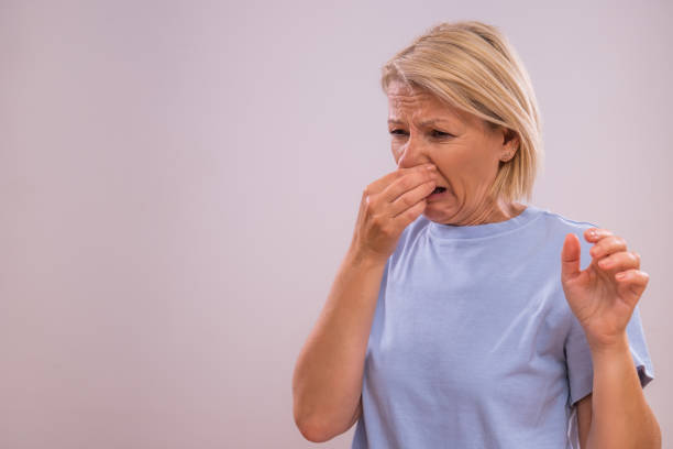 Unpleasant smell Shocked mature woman doesn't like how something smells. holding nose stock pictures, royalty-free photos & images