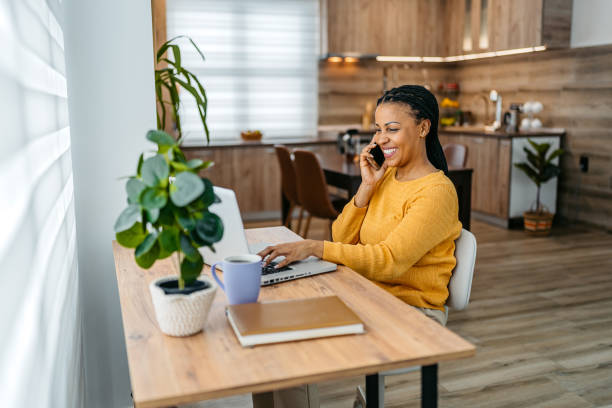 istock Young Woman Talking On The Phone While Working On A Laptop 2162104947