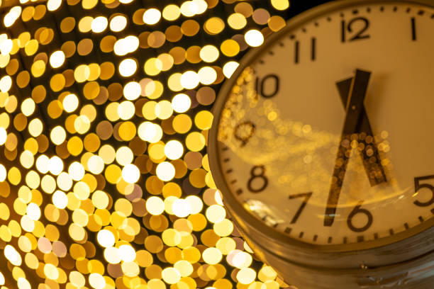 A mesmerizing golden clock, its hands elegantly poised, set against an abstract defocused background. The warm, shimmering hues create an atmosphere of anticipation, as if counting down to a significant moment.