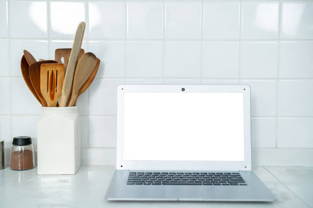 istock Mockup of laptop computer with empty screen sugar, spices in glass jars eggs, vegetable,tomato and a whisk on the kitchen on white table. Flat lay. Concept of food preparation, on background. 2162113918