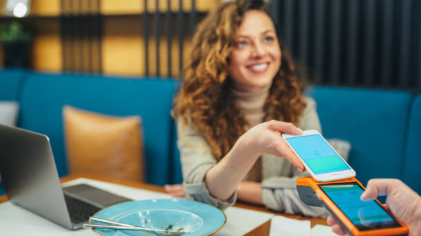 istock Woman in restaurant using digital wallet for mobile payment 2162115804