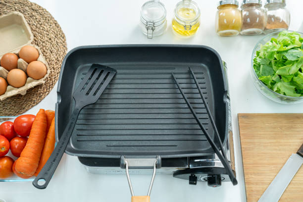istock Top view Empty cast iron frying pan ,sliced bread eggs, sugar, spices, vegetable,tomato and a whisk on the kitchen on white table. Flat lay. Concept of food preparation, kitchen on background. 2162116217