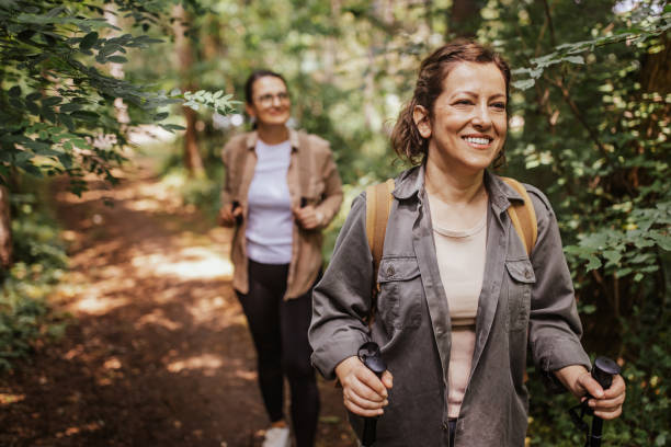 istock Women hiking together on forest path, smiling faces 2162116385