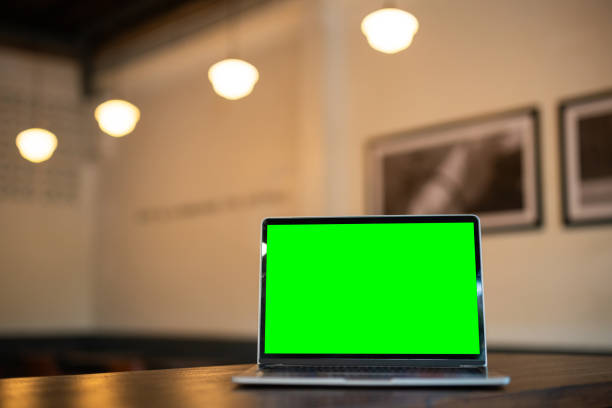 istock Mockup of laptop computer with empty screen on table side the window in the coffee shop at the cafe,green screen 2162116439