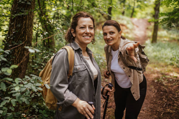 istock Two women hiking, one pointing, both smiling 2162116882
