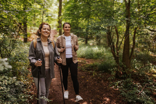 istock Two women walk with trekking poles on a forest trail. 2162117263