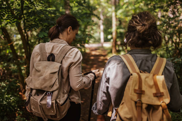 istock Two hikers with backpacks walking through a forest trail 2162118246