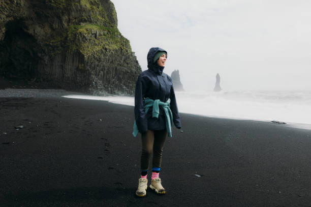 istock Cheerful Traveller Walking at Dramatic Black Sand Beach Admiring Ocean Views 2162118871