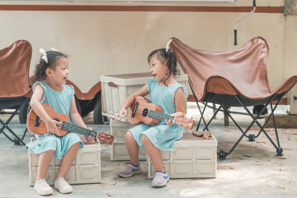 istock Adorable Twin Sisters Playing Ukuleles Outdoors 2162120706