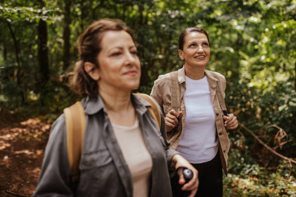 istock Two women hiking in forest, looking content and happy 2162120709