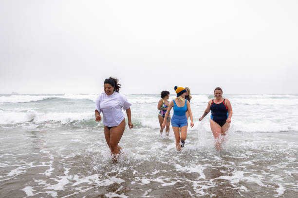 Too Cold! Wide shot of a group of women running out of the sea together. They are all wearing suitable swimming clothing. They are heading back towards the beach.
Videos are available similar to this scenario. woman cold water swimming stock pictures, royalty-free photos & images