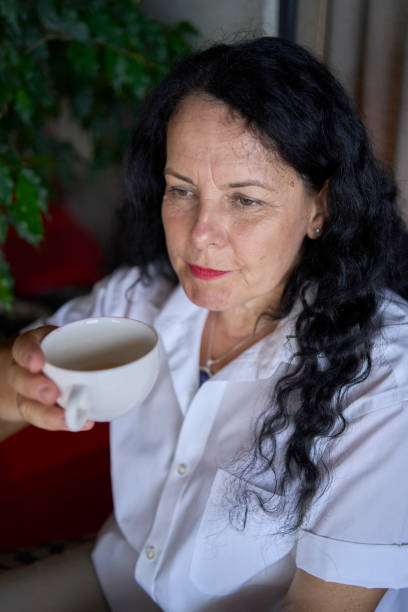 istock a 60s woman drinking nettle tea in modern coworking office during lunch break 2162125131