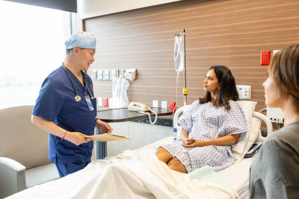 istock Mid adult male surgeon smiles reassuringly while explaining her upcoming procedure 2162128011