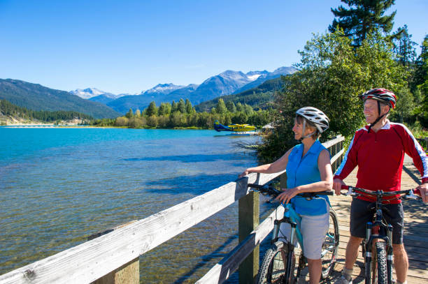 Senior couple explore lakeshore pathway on bicycles, Whistler, B.C.
