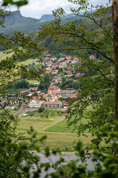 A small town with a church and houses. The town is surrounded by trees and grass