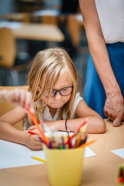 Young girl students paint and draw on class in the classroom