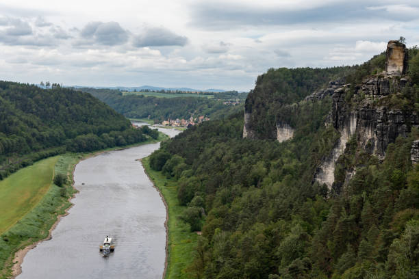 A boat is traveling down a river in a lush green valley