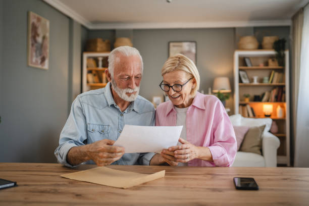 istock Senior couple read a letter document from envelope together at home 2162130048