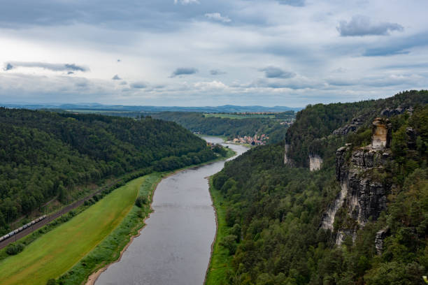 istock A river flows through a lush green valley with a train passing by 2162130116