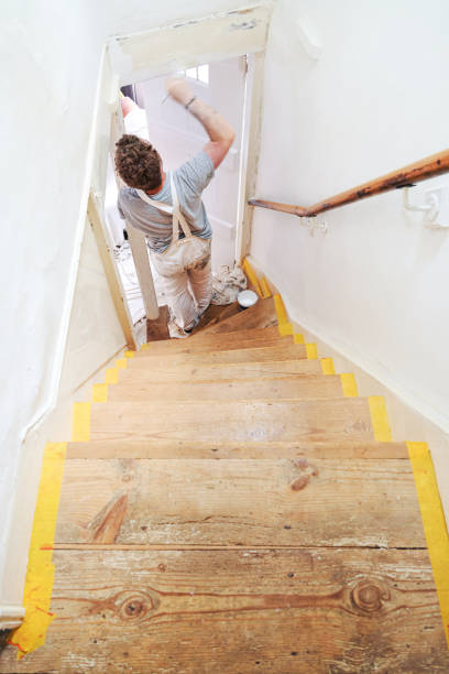 istock Young professional painter and decorator overcoming the disability of having one hand painting an old staircase door and frame. 2162130698