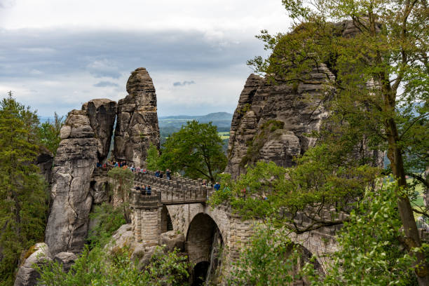 istock A group of people are walking across a bridge over a river 2162132091