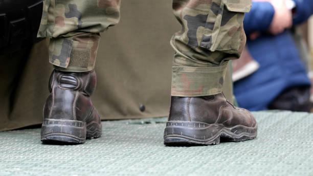 istock Generic anonymous army soldier legs boots closeup, camo uniforms, standing on the back of a military vehicle, detail shot. European American infantry soldiers simple abstract concept symbol, news shot 2162135936