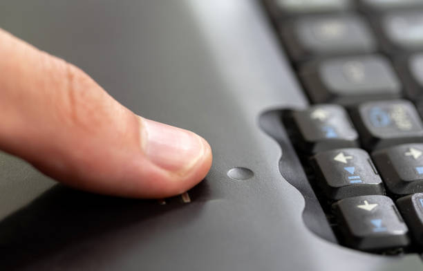 Man using a fingerprint scanner module built into a laptop, finger sliding on the fingerprint sensor detail closeup, one person. Biometric authentication, authenticating using a finger print signature