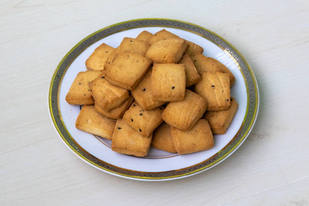 istock Delicious crispy biscuits serving on a white plate on wooden background. Tasty black cumin biscuits. 2162138492