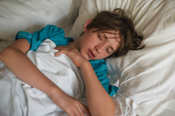 istock the boy sleeps on a white pillow, under a white blanket. 2162141562