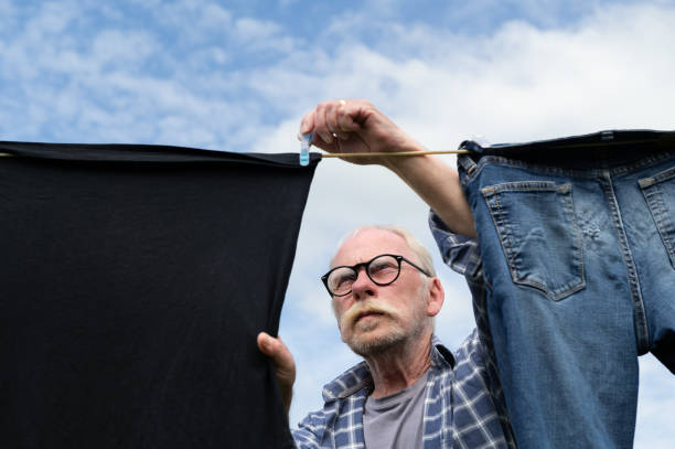 istock Senior man hanging clothes on a clothes line 2162141596