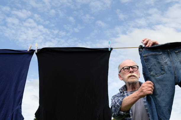 istock Mature man hanging clothes on a clothes line 2162141615