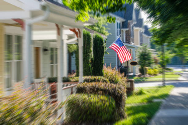 American Flags hang from the front of this traditional, brick homes in an All-American neighborhood.