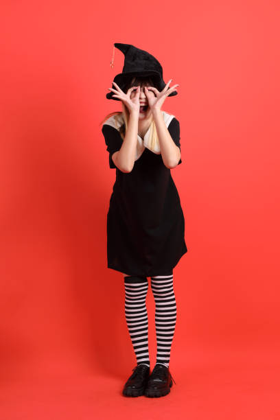 Happy young girl posing with photo booth props hat on black background