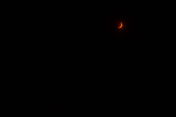 istock Face partial solar eclipse when the moon shadows the sun, making the star look like a slice of orange for observation it is essential to use glasses with solar filter. 2162146587