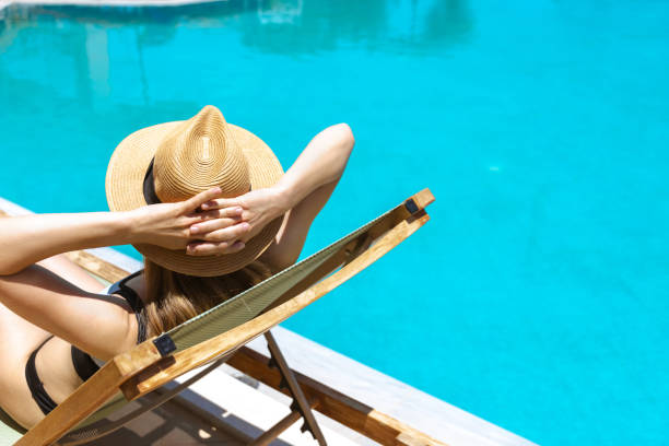 istock Woman sunbathing by the pool 2162147145