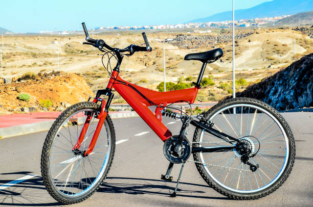 istock A red bicycle with a black seat is parked on a road 2162147250