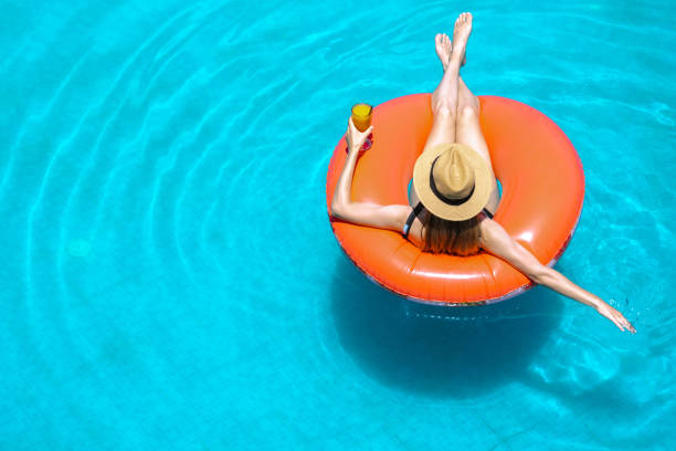 istock Young woman enjoys swimming pool 2162147282