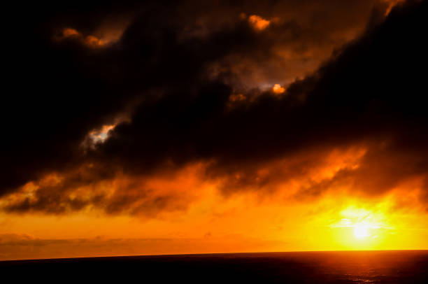 Clouds and sun with rays of light over ocean