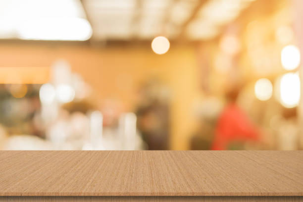abstract blur modern interior of bar restaurant with circle bokeh light and modern wood table perspective to show ads, and promote content or product on background