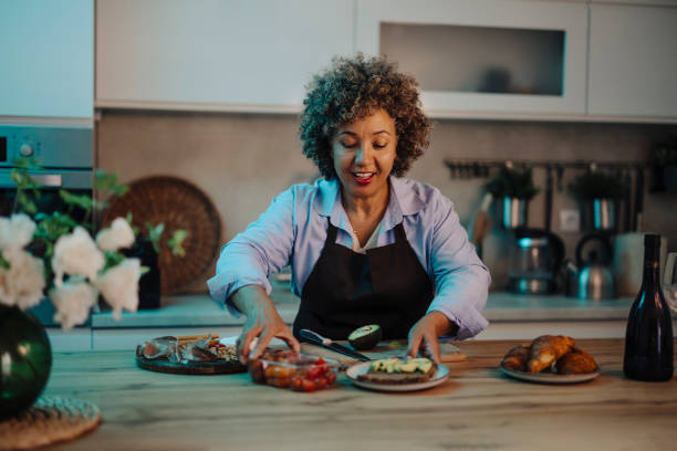 istock Mid adult mixed race woman preparing dinner at night 2162152129