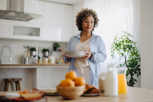 istock Mid adult mixed race Woman Setting the Table 2162152156