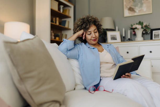 istock Woman reading book and resting at home 2162152220