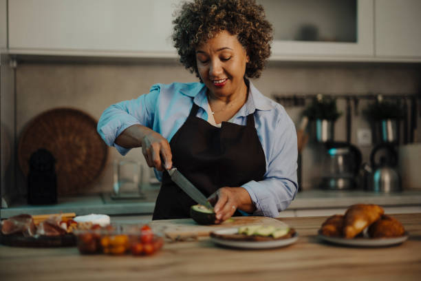 istock Mid adult mixed race woman preparing dinner at night 2162152258